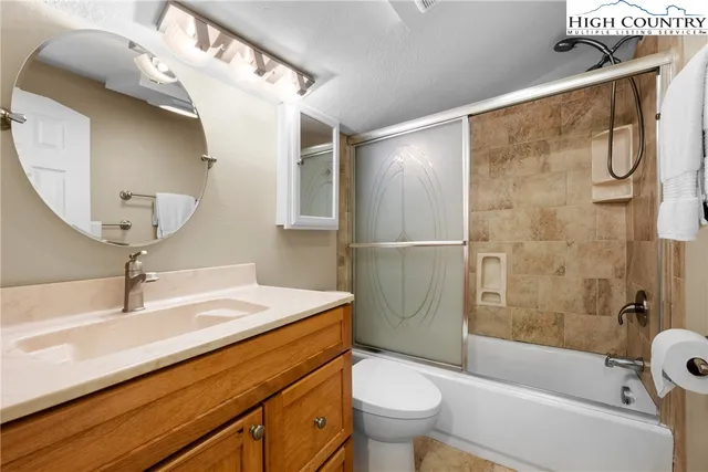 a bedroom with a bed and a lamp on dresser