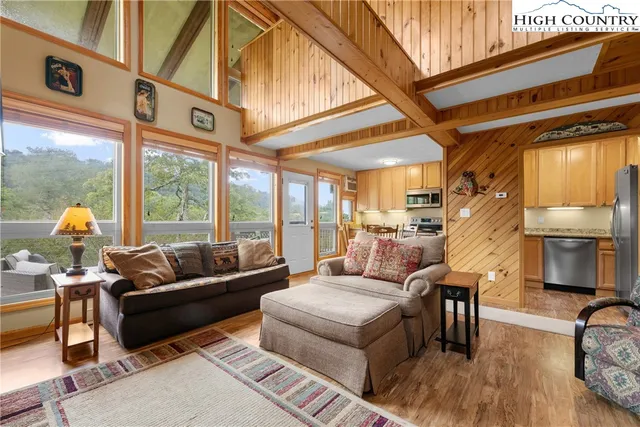 a kitchen with stainless steel appliances granite countertop a stove a refrigerator a sink a dining table and chairs with wooden floor