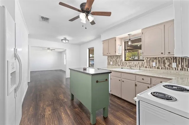 a kitchen with granite countertop a sink appliances cabinets and furniture