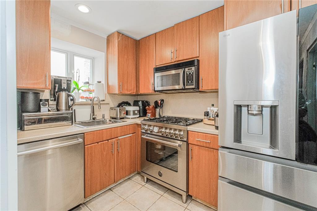 2809 East 28th Street, Unit 1C Brooklyn, NY 11235 - Photo 13 of 38 a kitchen with cabinets stainless steel appliances and a sink