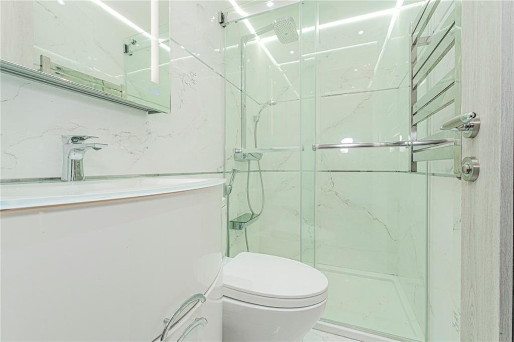 2809 East 28th Street, Unit 1C Brooklyn, NY 11235 - Photo 20 of 38 a bathroom with a toilet and shower