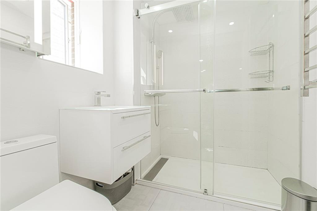 2809 East 28th Street, Unit 1C Brooklyn, NY 11235 - Photo 28 of 38 a bathroom with a sink a toilet and shower