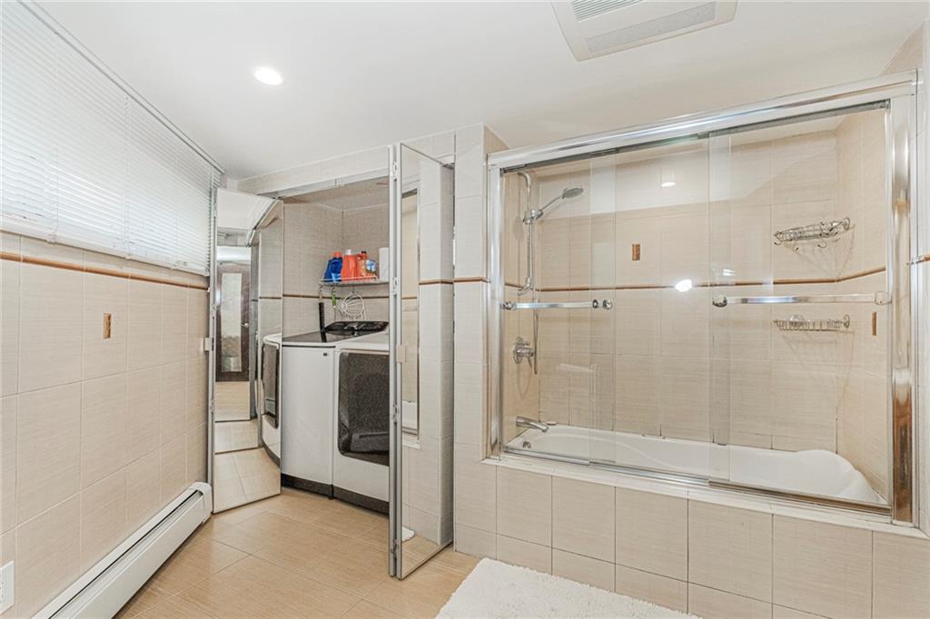 2809 East 28th Street, Unit 1C Brooklyn, NY 11235 - Photo 32 of 38 a bathroom with a shower and a bathtub