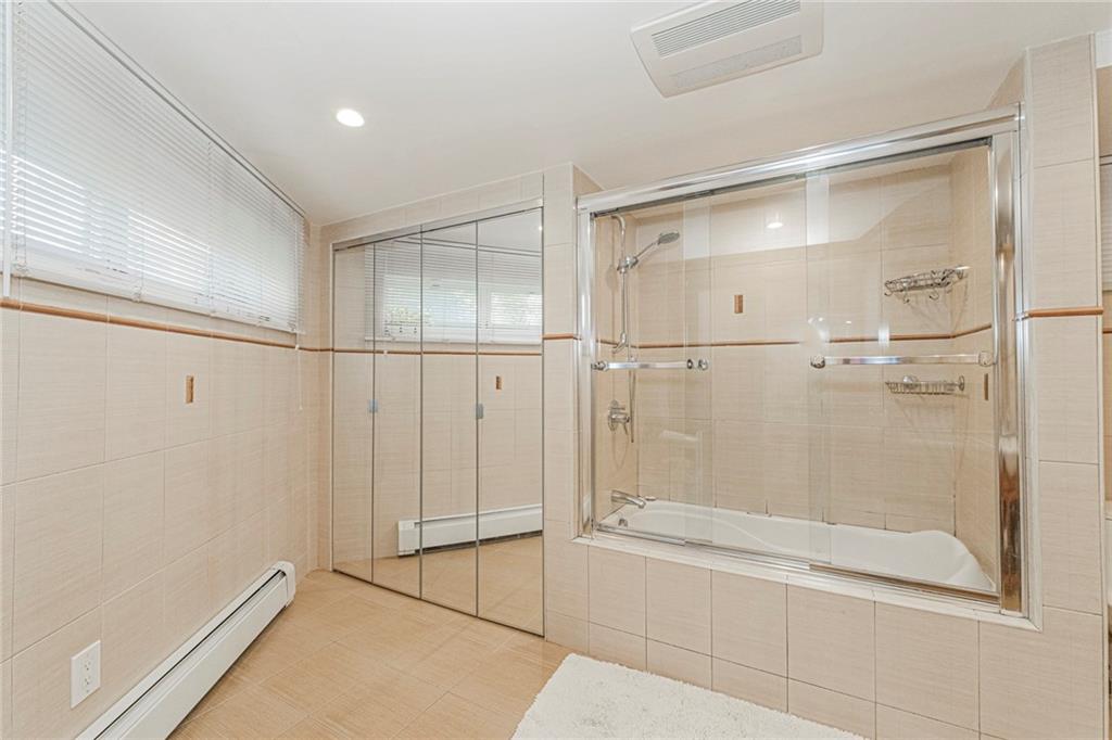 2809 East 28th Street, Unit 1C Brooklyn, NY 11235 - Photo 34 of 38 a bathroom with a glass shower door