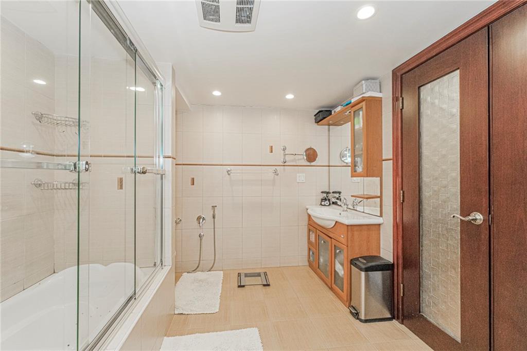 2809 East 28th Street, Unit 1C Brooklyn, NY 11235 - Photo 36 of 38 a bathroom with a bathtub and a shower