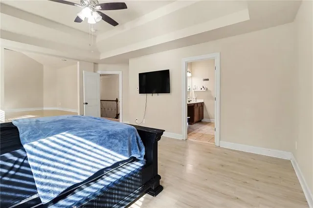 a bedroom with a bed and a flat tv screen on wall