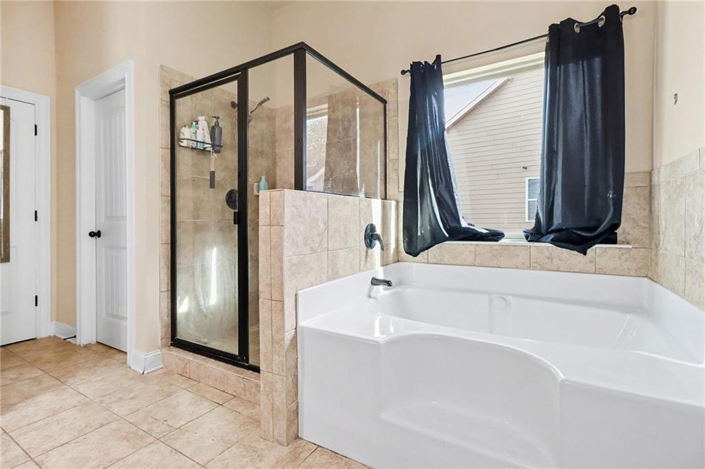 6791 Potomac Place Fairburn, GA 30213 - Photo 15 of 23 a bathroom with a bathtub and a shower