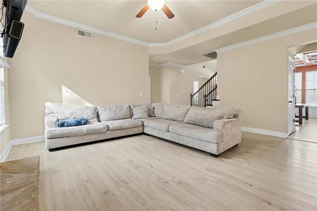 a living room with furniture and a wooden floor