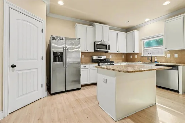a kitchen with kitchen island a white cabinets and white appliances