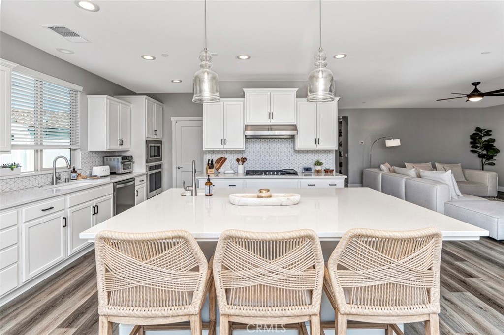 2018 Risborough Court Bakersfield, CA 93311 - Photo 16 of 73 a kitchen with stainless steel appliances kitchen island granite countertop a sink a stove a refrigerator and white cabinets
