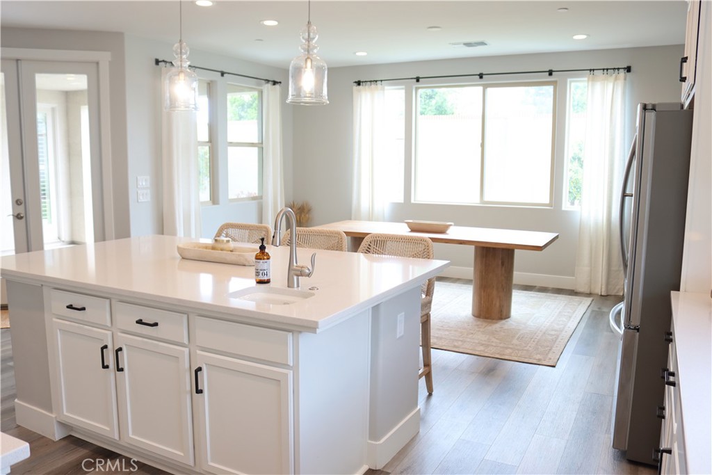 2018 Risborough Court Bakersfield, CA 93311 - Photo 18 of 73 a kitchen with stainless steel appliances granite countertop a sink a stove a refrigerator and island with wooden floor