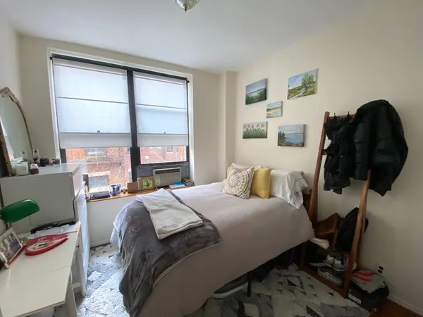 a bedroom with a bed and a window