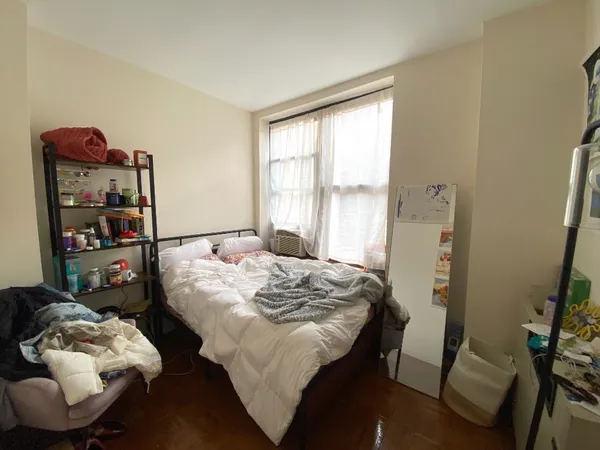 a bed sitting in a bedroom next to a window