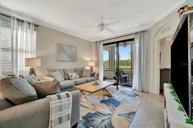 a living room with furniture kitchen view and a chandelier