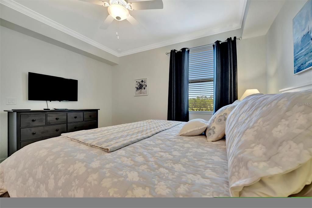 17724 Gawthrop Drive, Unit 101 Bradenton, FL 34211 - Photo 16 of 28 a bedroom with a bed and a flat screen tv