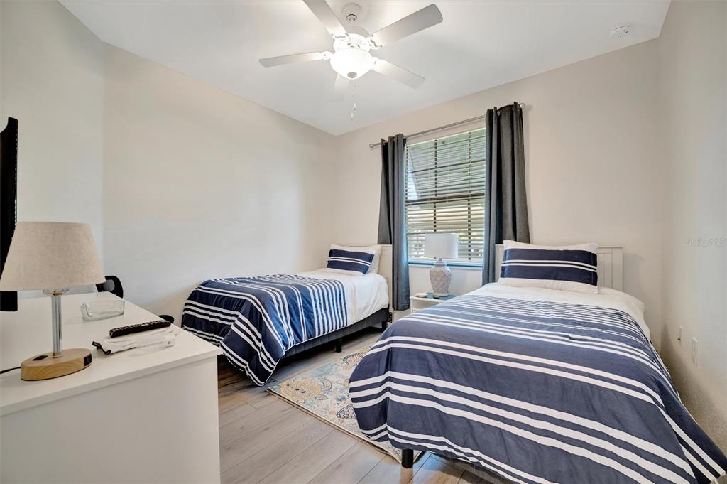 17724 Gawthrop Drive, Unit 101 Bradenton, FL 34211 - Photo 18 of 28 a bedroom with two beds and a chandelier