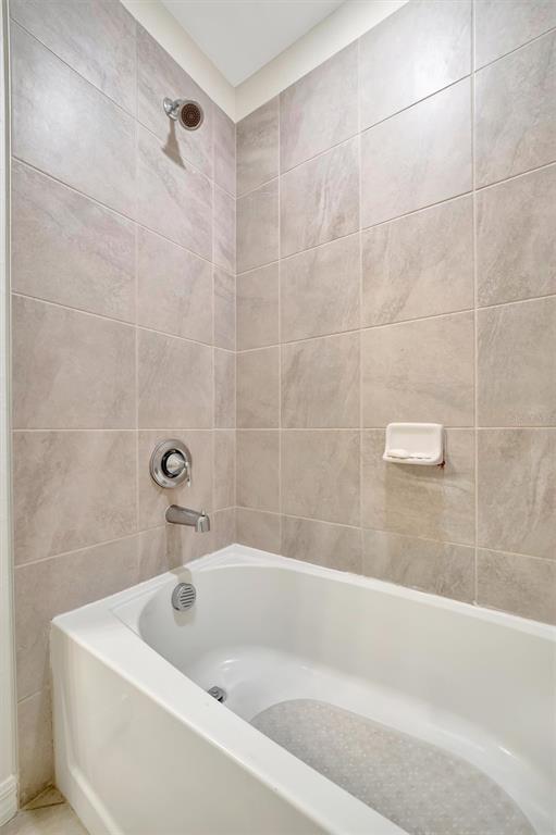 17724 Gawthrop Drive, Unit 101 Bradenton, FL 34211 - Photo 23 of 28 a white bath tub sitting in a bathroom