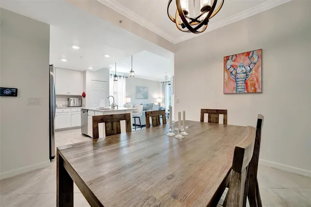 a dining hall with stainless steel appliances granite countertop a stove top oven a dining table and chairs with wooden floor