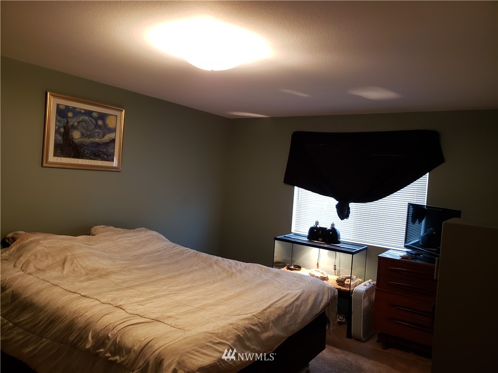 18301 Brandywine Court Southwest Rochester, WA 98579 - Photo 19 of 25 a bedroom with a bed and wooden floor