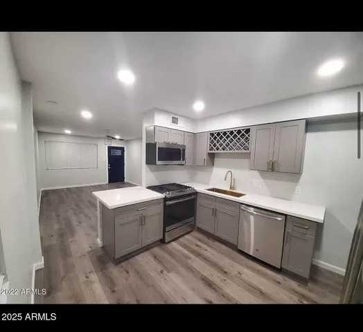 a large white kitchen with stainless steel appliances