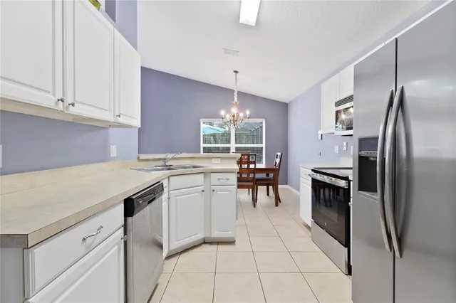 a kitchen with kitchen island white cabinets and stainless steel appliances