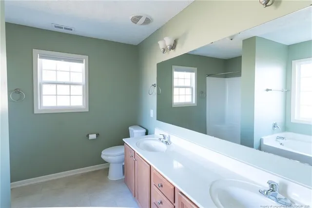 a spacious bathroom with a toilet sink and mirror