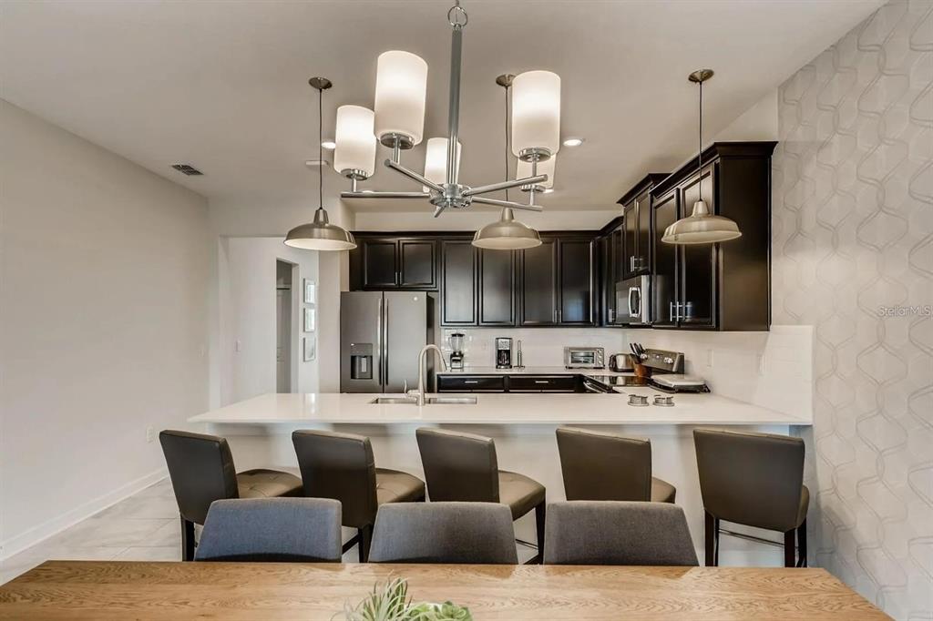 545 Ocean Course Avenue, Unit 545 Davenport, FL 33896 - Photo 13 of 32 a living room with furniture kitchen view and a wooden floor