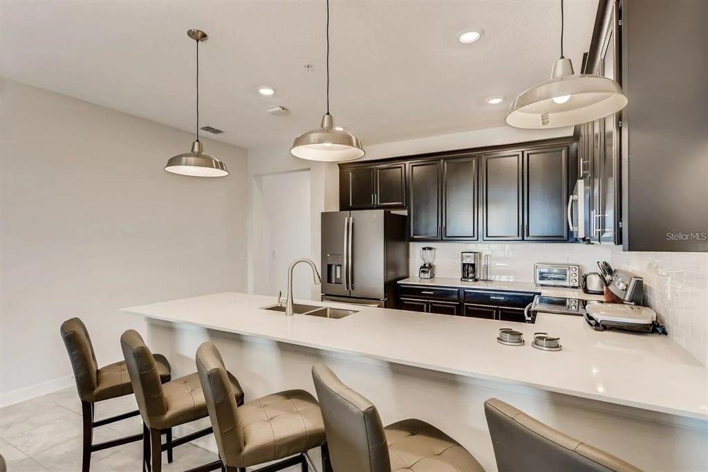 545 Ocean Course Avenue, Unit 545 Davenport, FL 33896 - Photo 14 of 32 a kitchen with a dining table and chairs