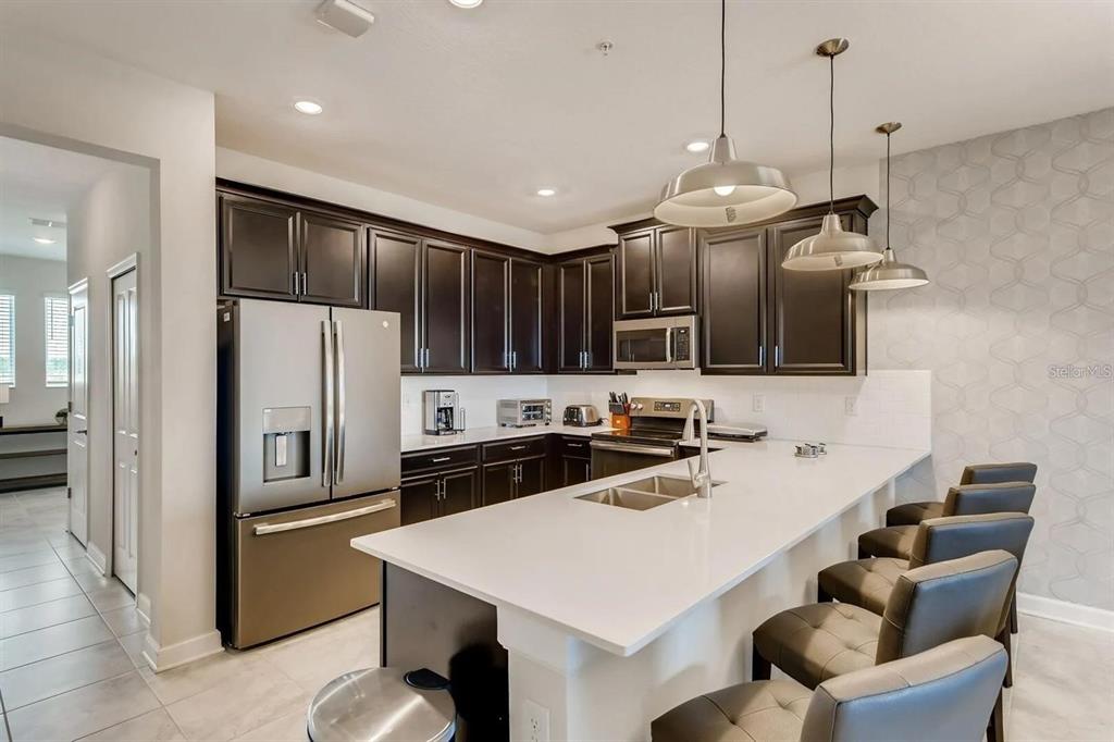545 Ocean Course Avenue, Unit 545 Davenport, FL 33896 - Photo 15 of 32 a kitchen with granite countertop a sink stainless steel appliances and cabinets
