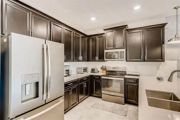 a kitchen with stainless steel appliances granite countertop a sink stove and refrigerator