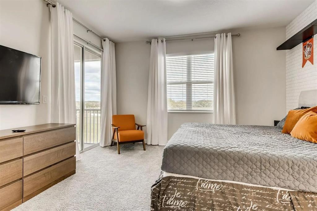 545 Ocean Course Avenue, Unit 545 Davenport, FL 33896 - Photo 18 of 32 a bedroom with a bed and flat screen tv