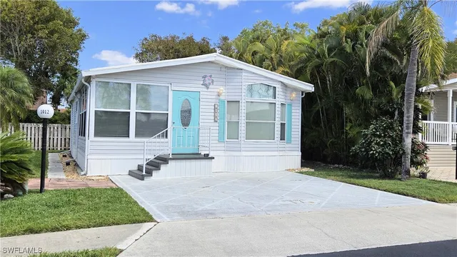 a front view of a house with a yard and potted plants