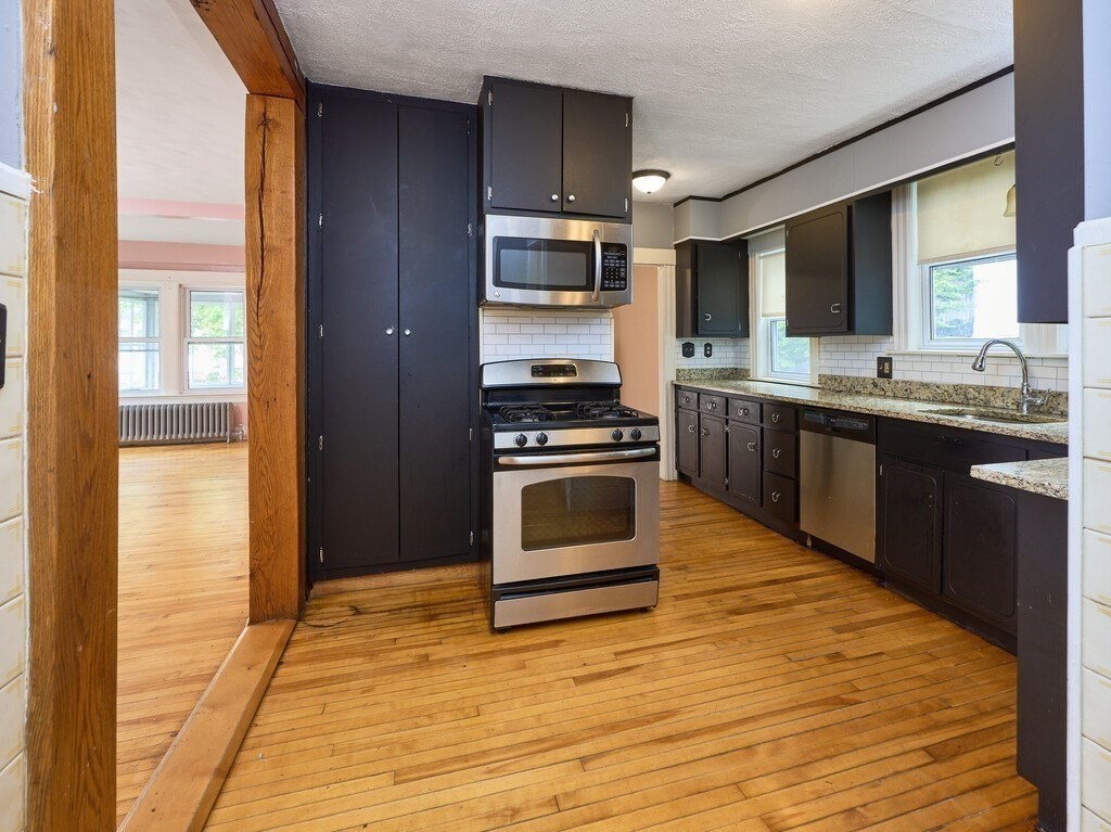 88 Beaconsfield Road Worcester, MA 01602 - Photo 12 of 34 a kitchen with stainless steel appliances kitchen island granite countertop a stove and a sink