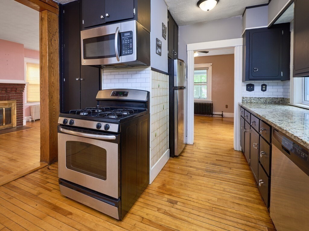 88 Beaconsfield Road Worcester, MA 01602 - Photo 13 of 34 a kitchen with stainless steel appliances granite countertop a stove and a wooden floors