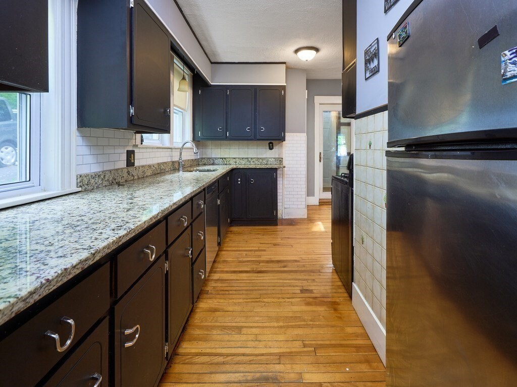 88 Beaconsfield Road Worcester, MA 01602 - Photo 10 of 34 a kitchen with stainless steel appliances granite countertop a sink stove and refrigerator