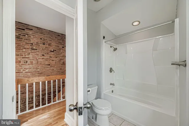 a bathroom with a granite countertop bathtub shower sink vanity and toilet