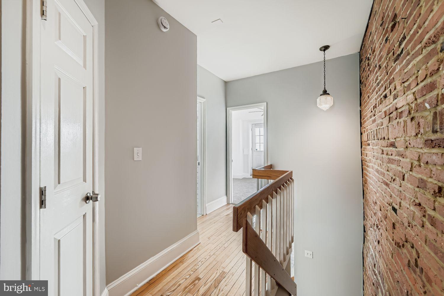 3143 Dillon Street Baltimore, MD 21224 - Photo 19 of 26 Charming hallway with exposed brick accents.