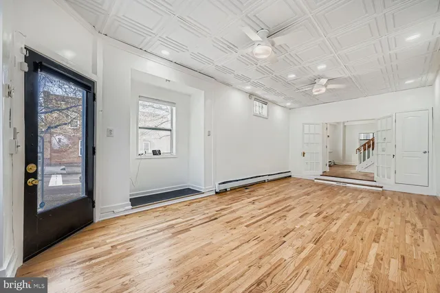 a view of empty room with window and wooden floor