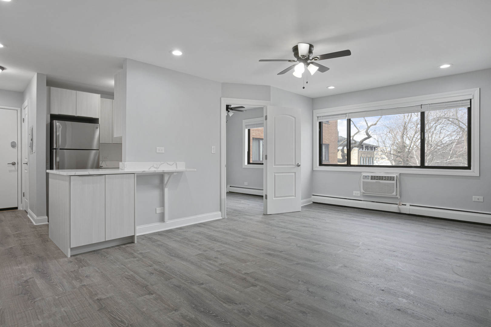 6826 North Ridge Boulevard, Unit 305 Chicago, IL 60645 - Photo 2 of 13 an empty room with wooden floor cabinet and windows