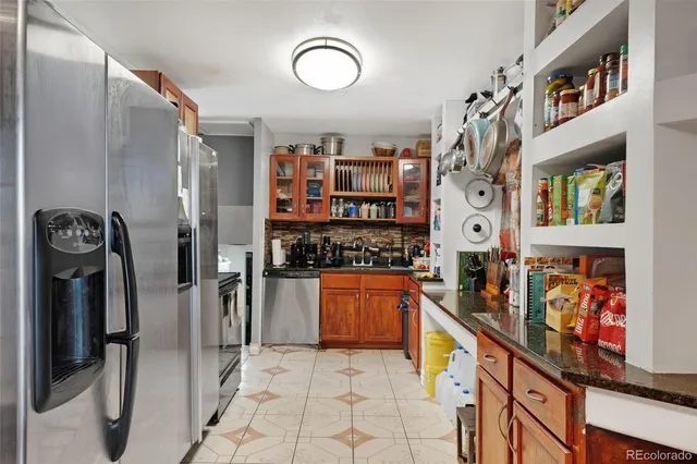 a kitchen with stainless steel appliances granite countertop a refrigerator and a stove top oven