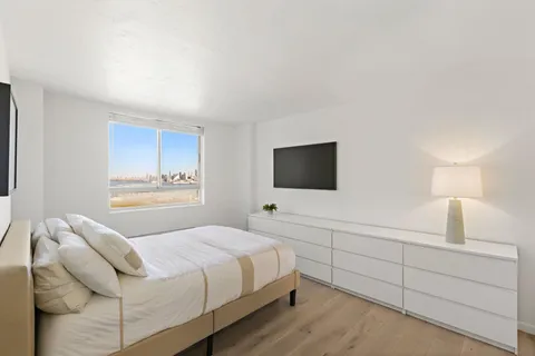 a bedroom with a bed and a flat screen tv