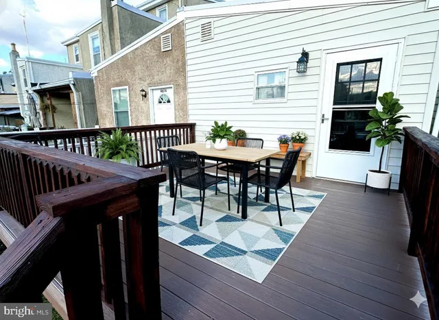 a view of a roof deck with table and chairs with wooden floor and fence