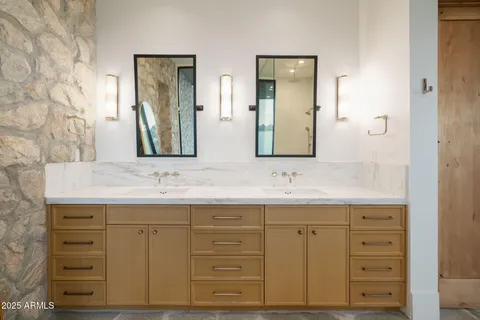 a bathroom with a granite countertop sink vanity and mirror