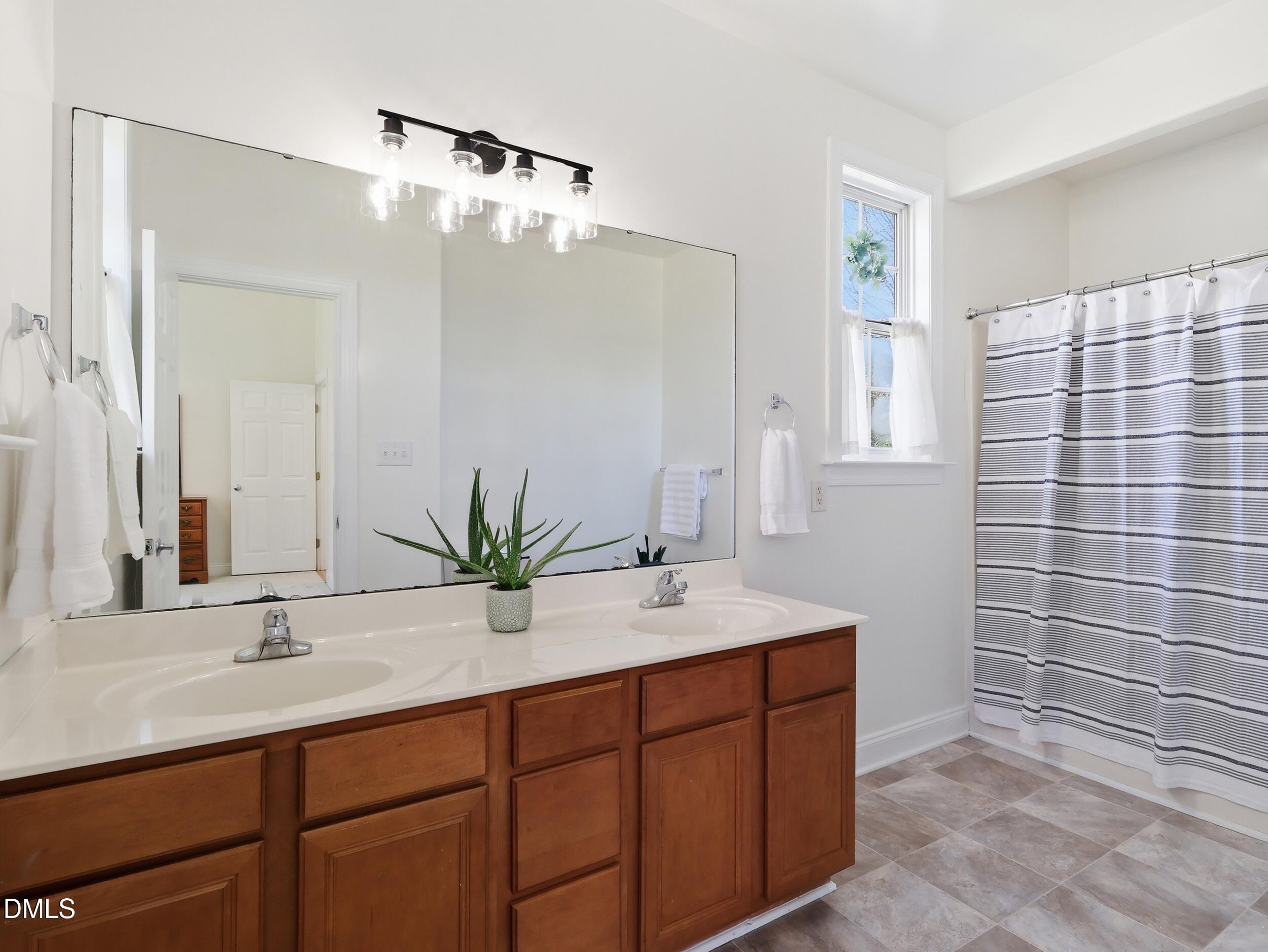 10 Kinderkamack Road Youngsville, NC 27596 - Photo 17 of 46 a bathroom with a double vanity sink mirror and shower
