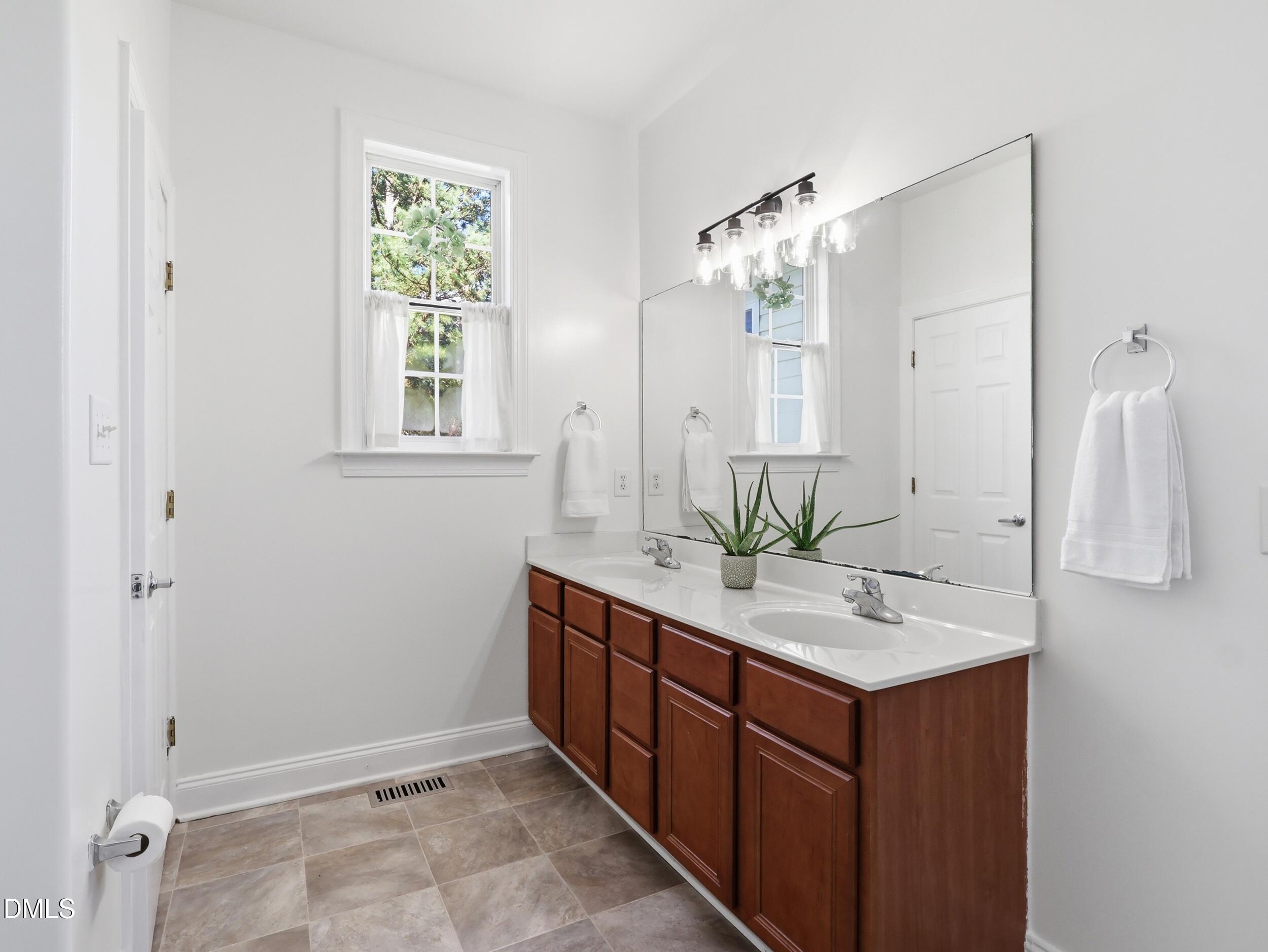 10 Kinderkamack Road Youngsville, NC 27596 - Photo 18 of 46 a bathroom with a double vanity sink and a mirror