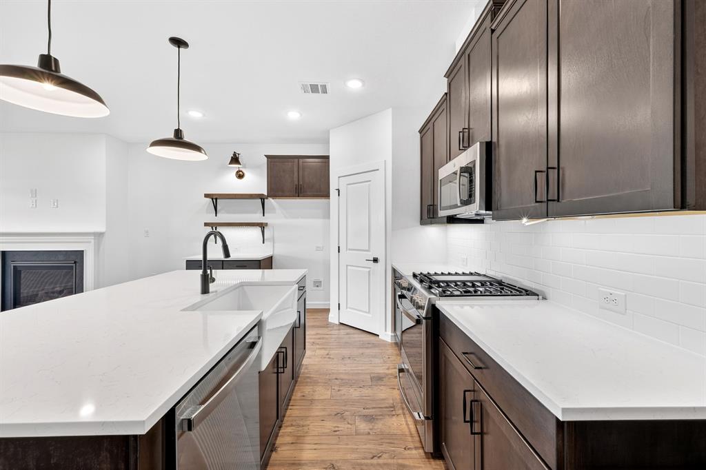 1313 Richardson Street Howe, TX 75459 - Photo 14 of 28 a kitchen with a stove a refrigerator and a sink