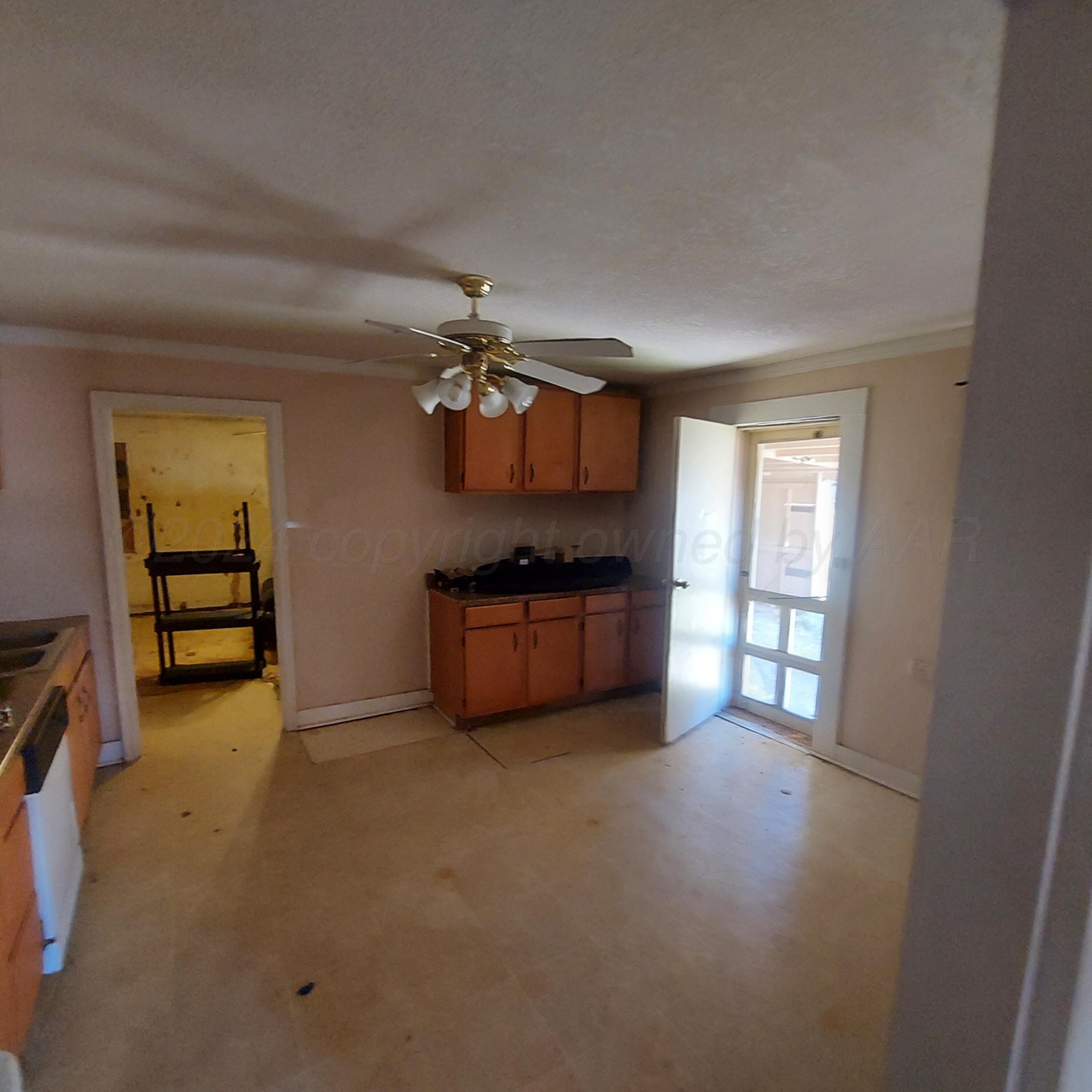 1608 Backus Street Paducah, TX 79248 - Photo 14 of 21 Kitchen with dark countertops, crown molding, wood finish cabinetry, a ceiling fan, and white dishwasher