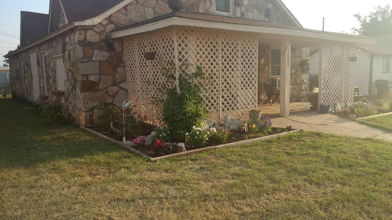 1608 Backus Street Paducah, TX 79248 - Photo 4 of 21 View of property exterior with stone siding, a lawn, and a porch