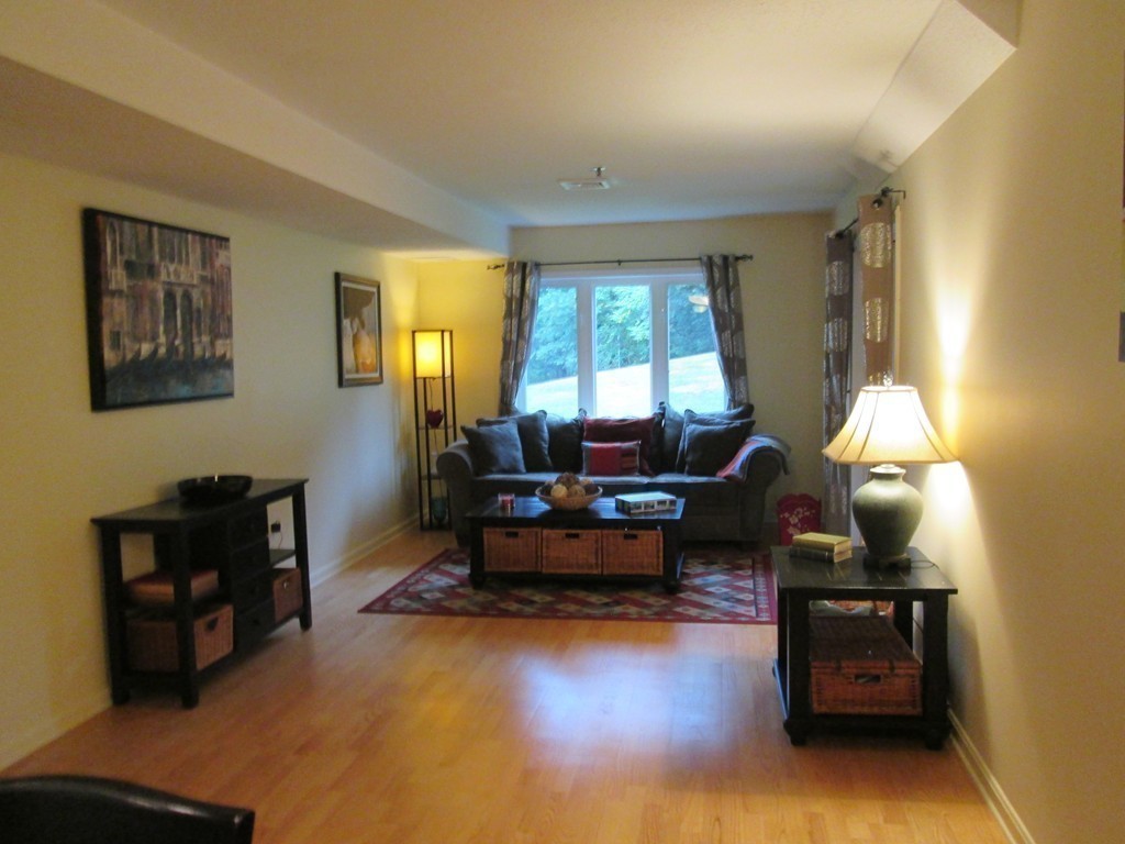 4 Duck Pond Road, Unit 204 Beverly, MA 01915 - Photo 11 of 23 a living room with furniture and a wooden floor