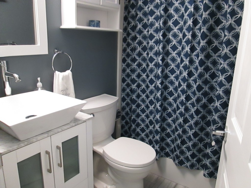 4 Duck Pond Road, Unit 204 Beverly, MA 01915 - Photo 19 of 23 a white toilet sitting next to a shower curtain